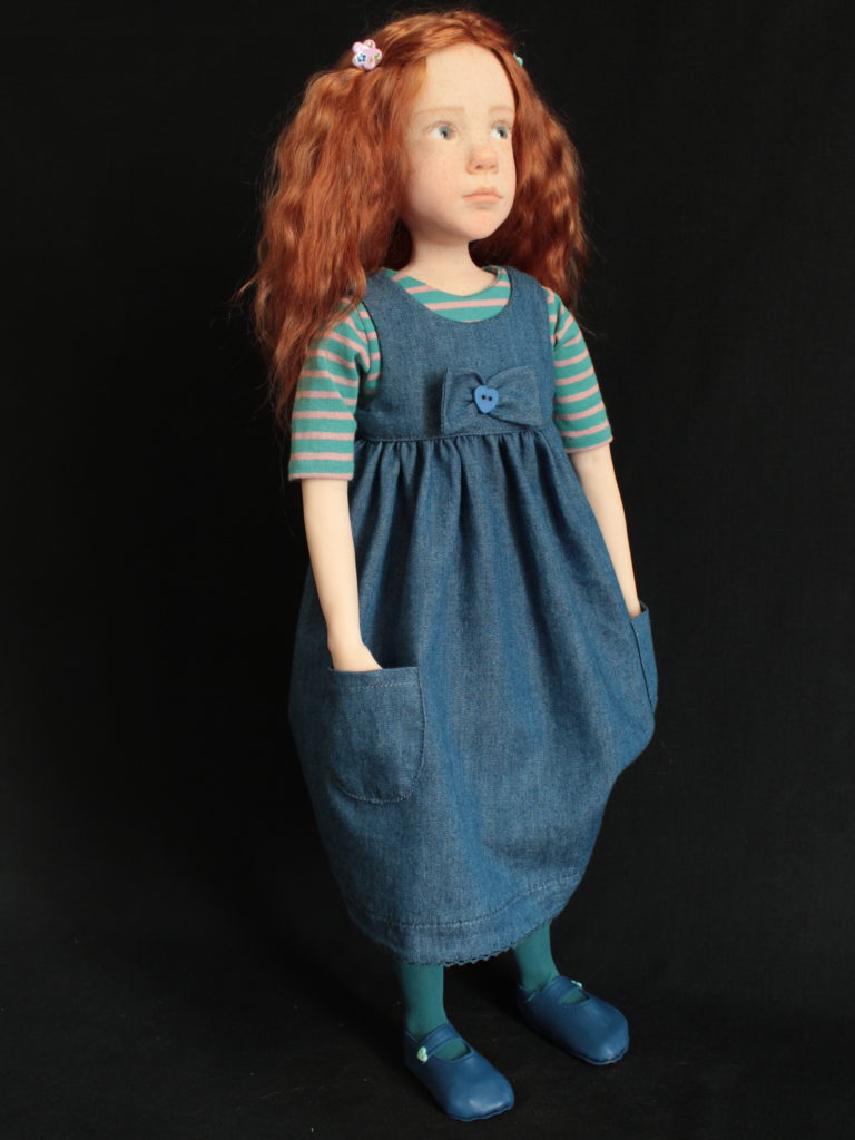 Petite fille rousse avec une robe en jean