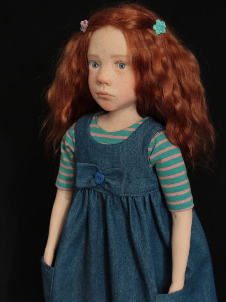 Petite fille rousse avec une robe en jean