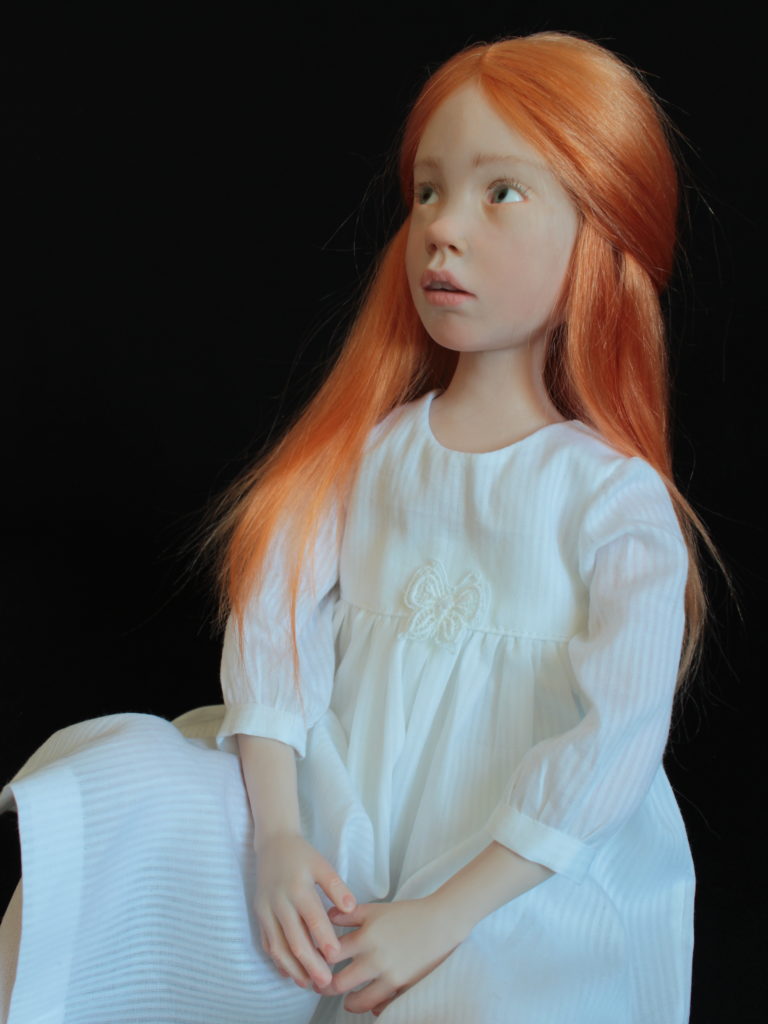 "Petite fille rousse assise en blanc"