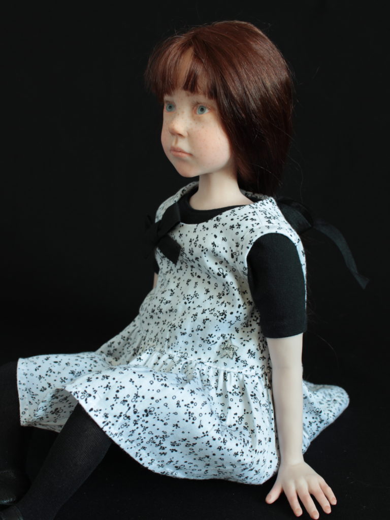 "Petite fille brune assise en noir et blanc"