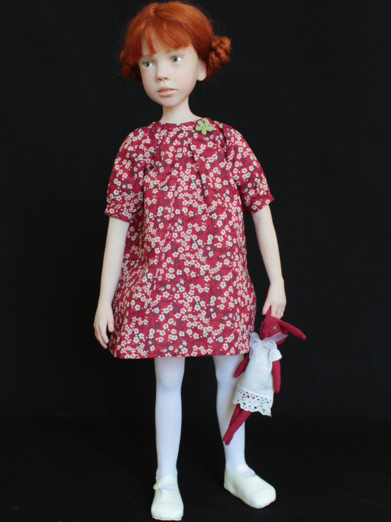 Petite fille rousse avec une robe rouge