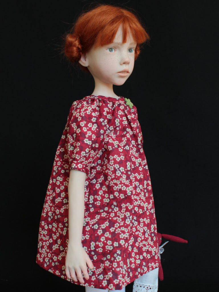 Petite fille rousse avec une robe rouge