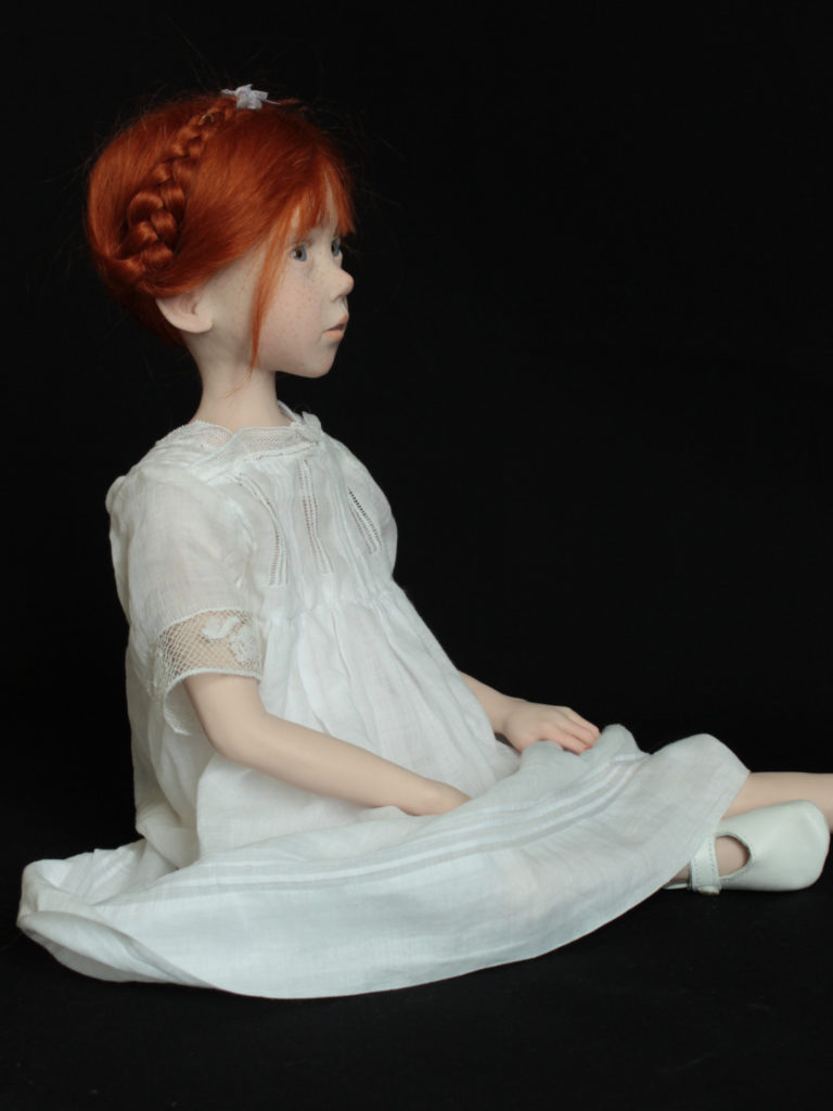 "Petite fille rousse assise en robe blanche"