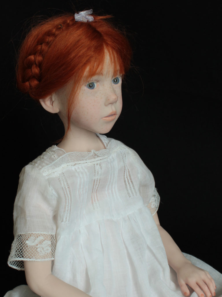 "Petite fille rousse assise en robe blanche"