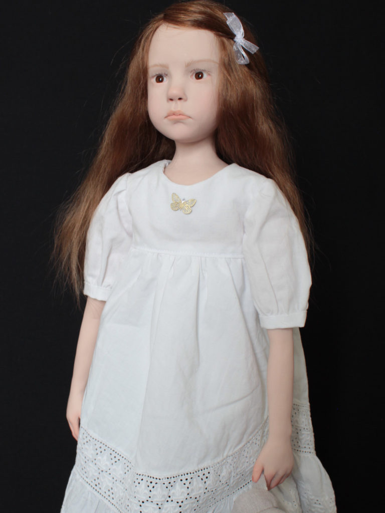 "Petite fille brune habillée en blanc"
