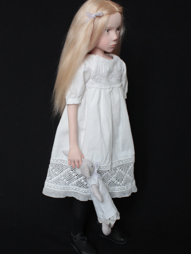 "Petite fille blonde habillée en blanc"