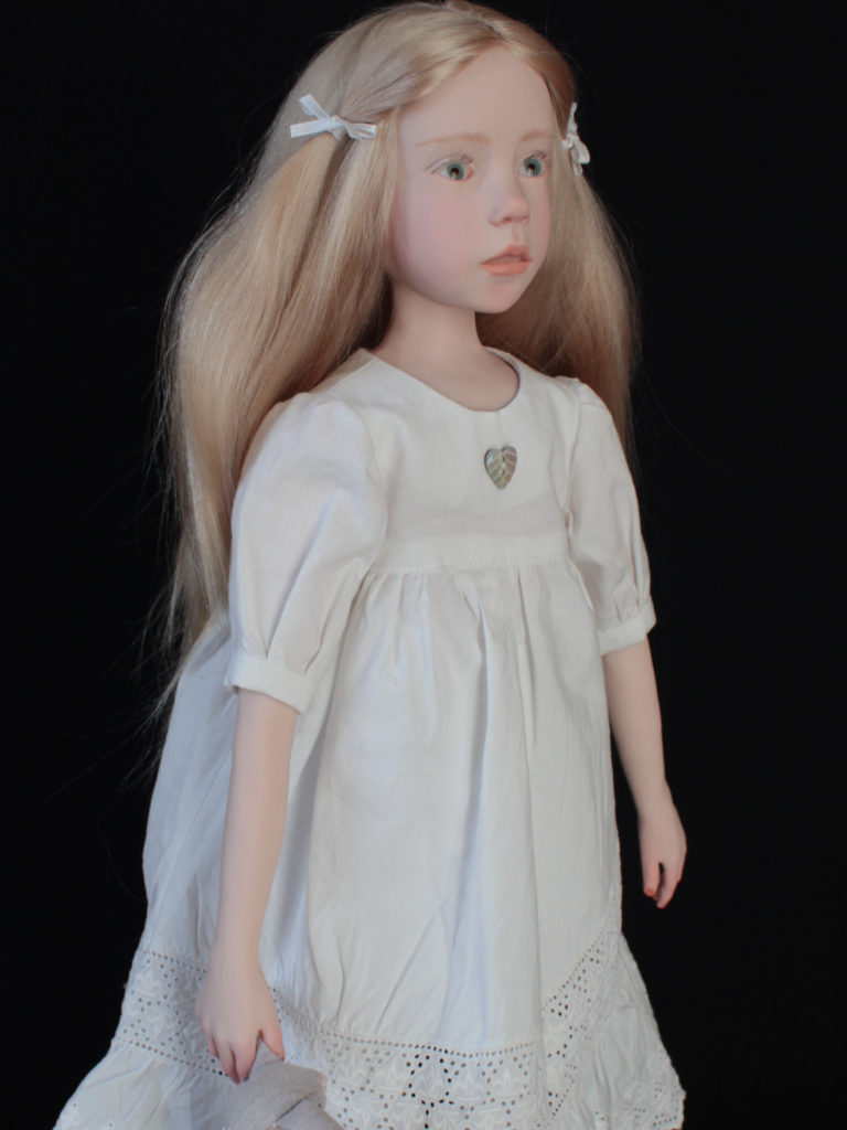 "Petite fille blonde en robe blanche"
