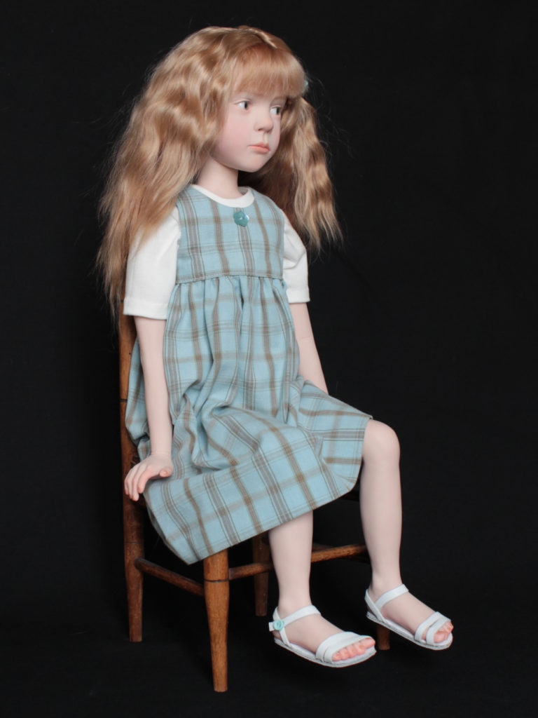 "Petite fille châtain assise sur une chaise"
